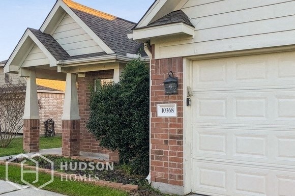 a white garage door in front of a brick house