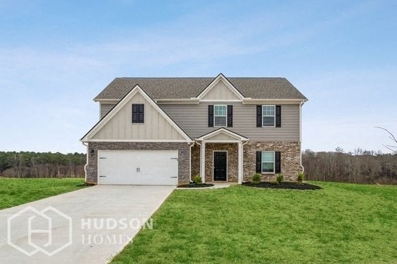 a house with a green lawn and a white garage door