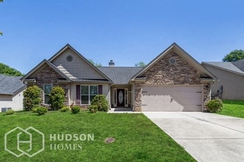 a house with a driveway and lawn in front of it