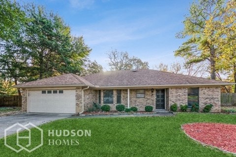 a brick house with a lawn and a driveway