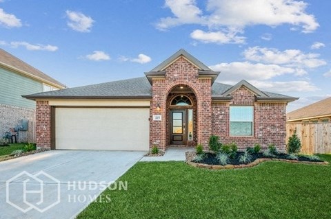a single story brick house with a garage and a lawn