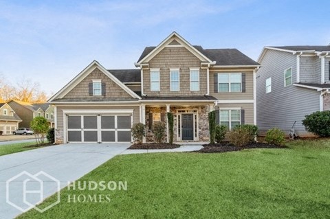 a house with a driveway and lawn in front of it