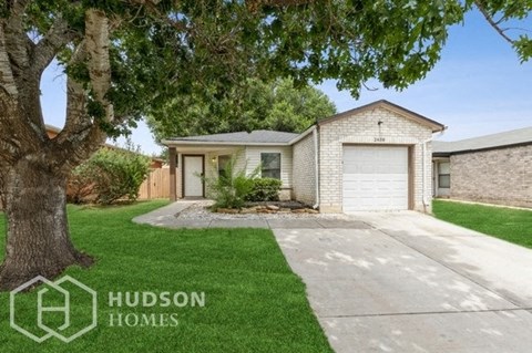 a white brick house with a white garage door and a lawn