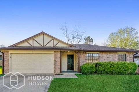 a small brick house with a lawn