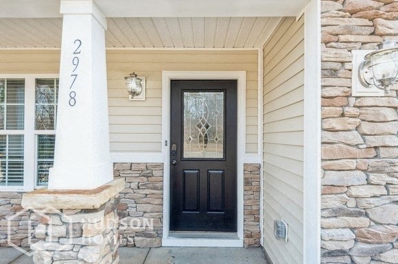 the front door of a stone house with a black door