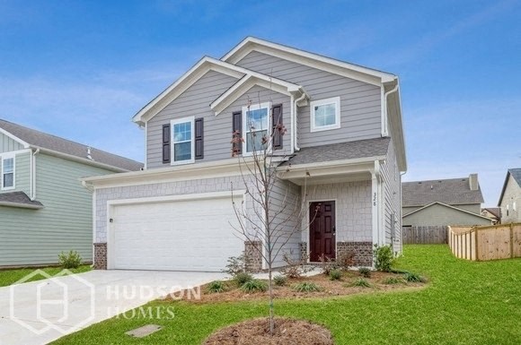 a house with a garage door and a lawn