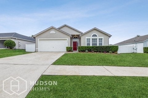 a house with a red door and a lawn