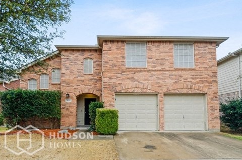 a brick house with two garage doors