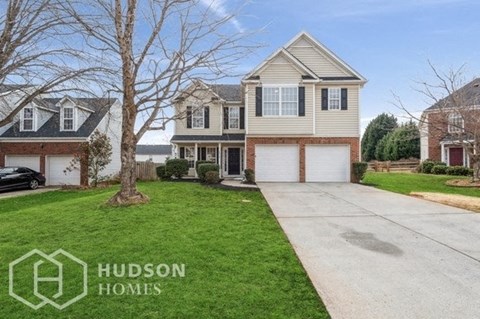 a house with two garage doors and a lawn