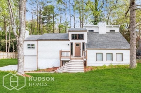 a small white house with a porch and stairs