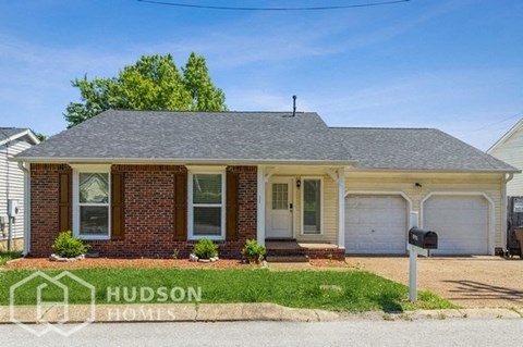 a small brick house with a mailbox in front of it