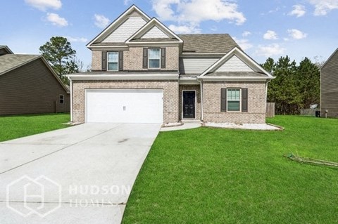 a house with a white garage door in front of a green lawn