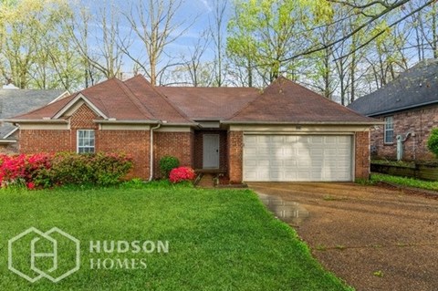 a brick house with a driveway and a garage door