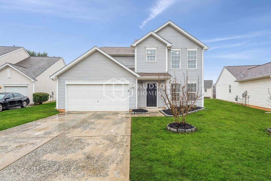a white house with a lawn and a driveway
