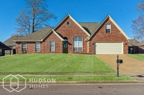 a brick house with a lawn and a parking meter