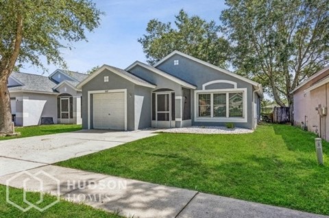 a blue house with a lawn and a driveway