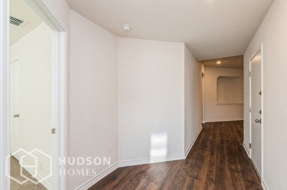 a renovated living room with white walls and wood flooring