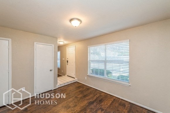 a living room with a large window and a door to a bathroom