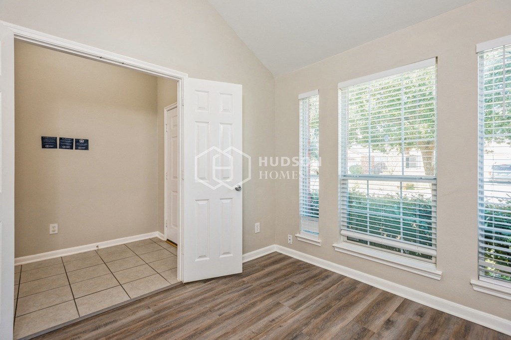 a bedroom with a large window and a white door