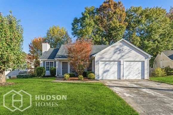 a white house with a white garage door and a lawn