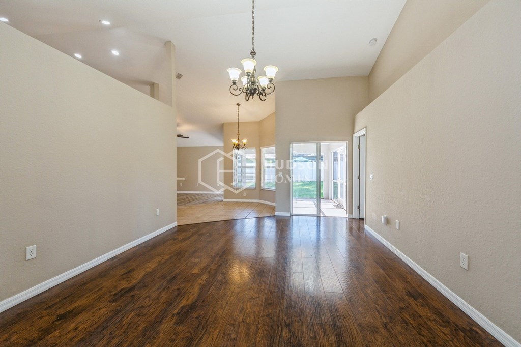 a living room and dining room with hardwood floors and a chandelier