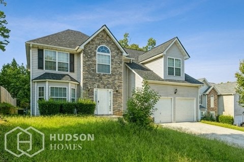 a house with two garage doors and a lawn in front of it