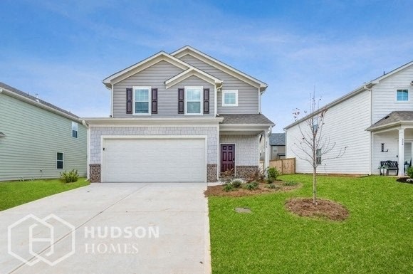 a white house with a white garage door and a lawn