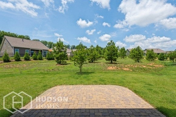 a backyard with a cobblestone driveway and some trees