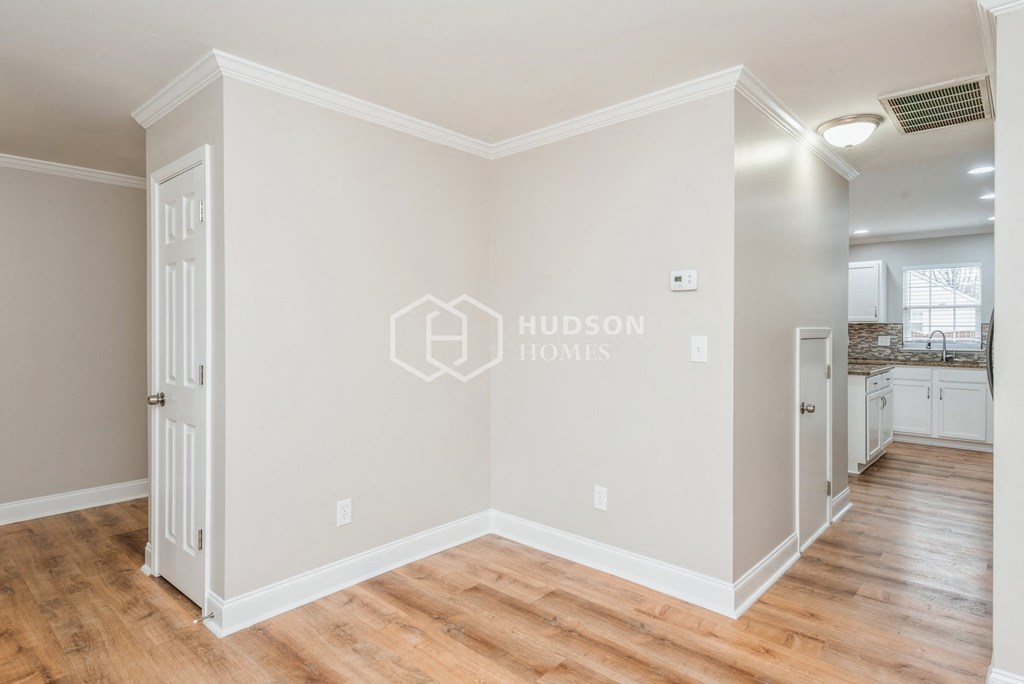a renovated living room with white walls and wood floors
