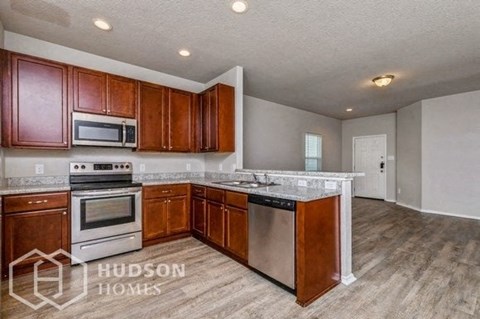 A kitchen with wooden cabinets and stainless steel appliances is on the market with Hudson Homes.