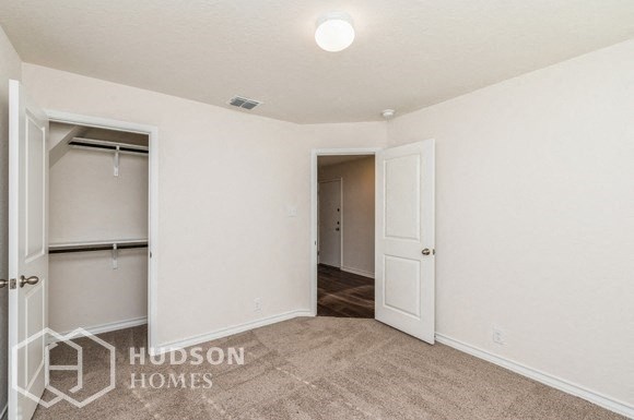 an empty bedroom with a closet and a door to a closet