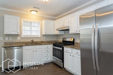 a kitchen with white cabinets and a stainless steel refrigerator