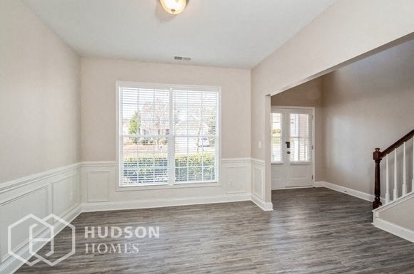 an empty living room with a staircase and a large window