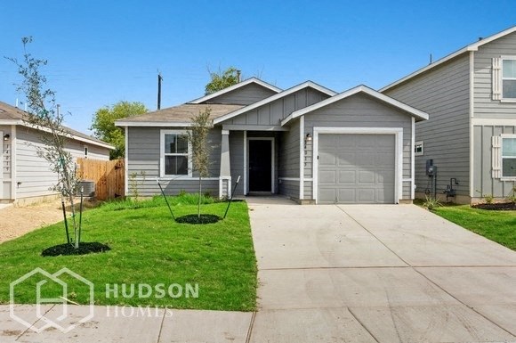a gray house with a driveway and a garage door