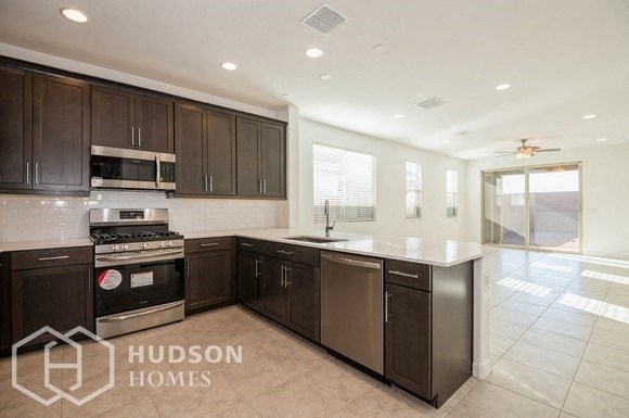 a large kitchen with wooden cabinets and stainless steel appliances