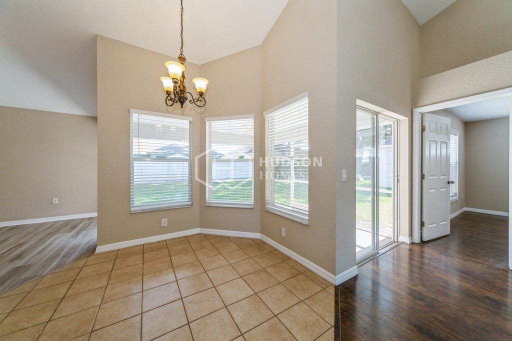 an empty living room with windows and a door to a patio