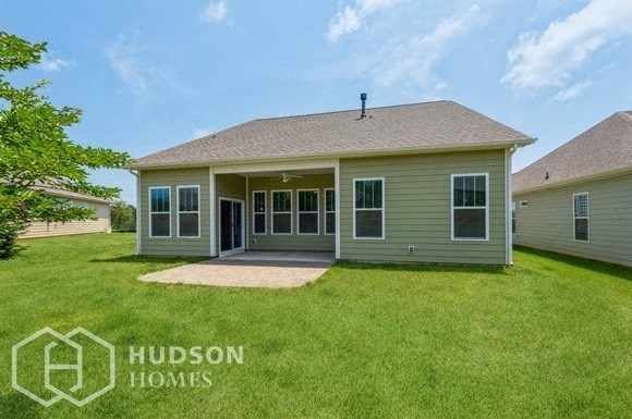 a green house with a lawn and a blue sky