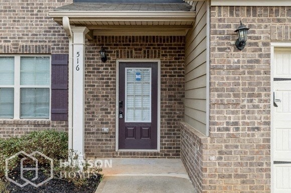 the front of a brick house with a purple door