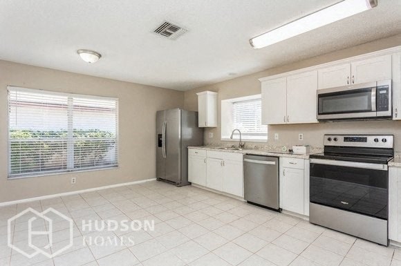 a kitchen with a stove refrigerator and a microwave
