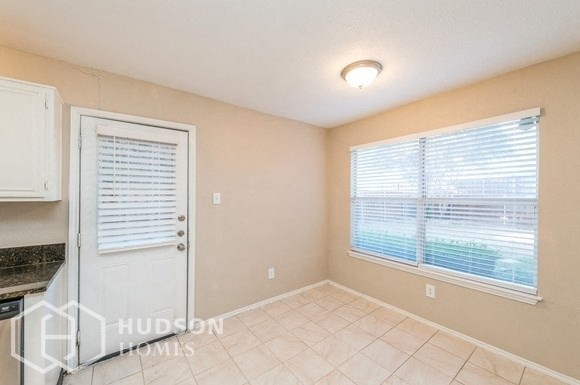 a small kitchen with a large window and a white door