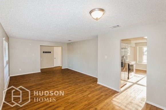 an empty living room and dining room with wood flooring