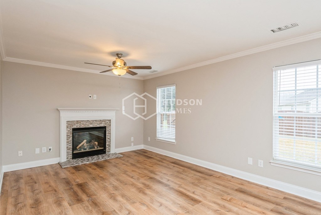 a living room with a fireplace and a ceiling fan