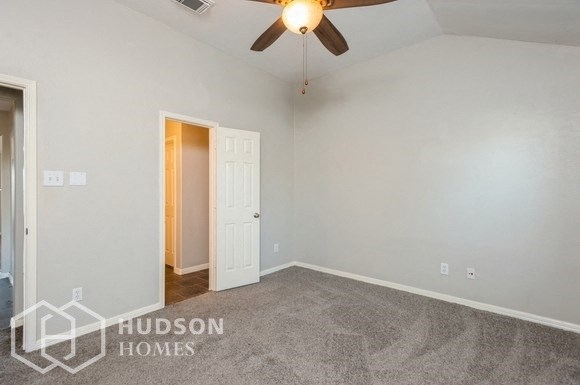 an empty room with a ceiling fan and a door to a closet