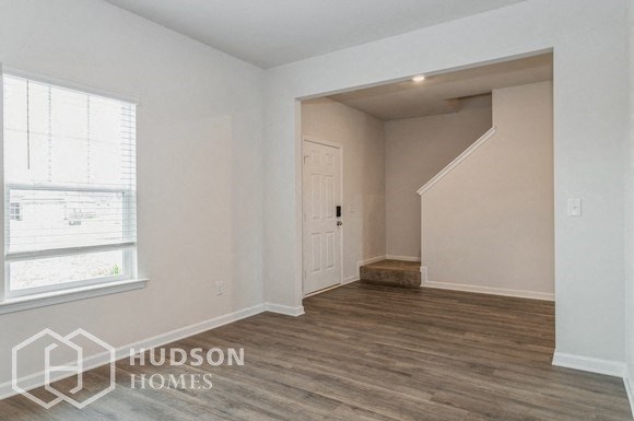 an empty living room with a door and a window