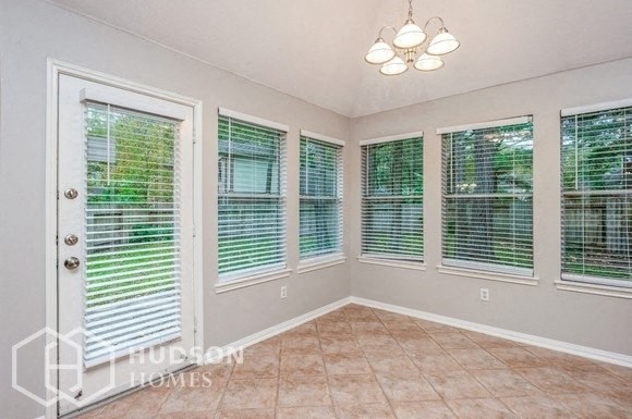 an empty living room with windows and a door to a backyard
