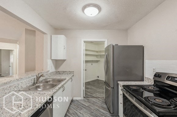 a kitchen with a stove and a refrigerator and a sink