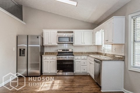 a white kitchen with stainless steel appliances and white cabinets