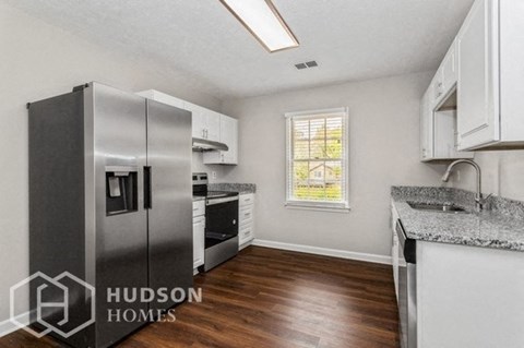 a kitchen with a refrigerator and a sink and a window