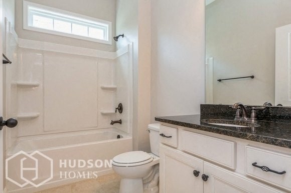 a bathroom with a toilet and a sink and a bath tub