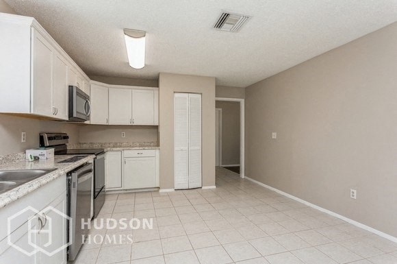 a kitchen with white cabinets and a stove and a sink